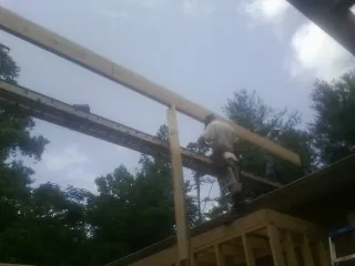 Carpenter setting a ridge beam over a new addition frame — Ice Dam Removal by Roofing Brothers in Keymar